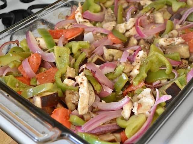 stirred and cooked veggies and chicken in baking dish 