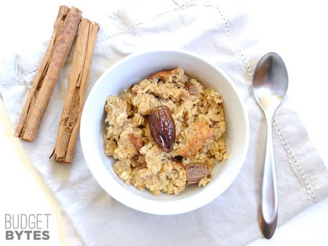 Top view of a bowl of Cinnamon Date Walnut Oatmeal with a spoon on the side 