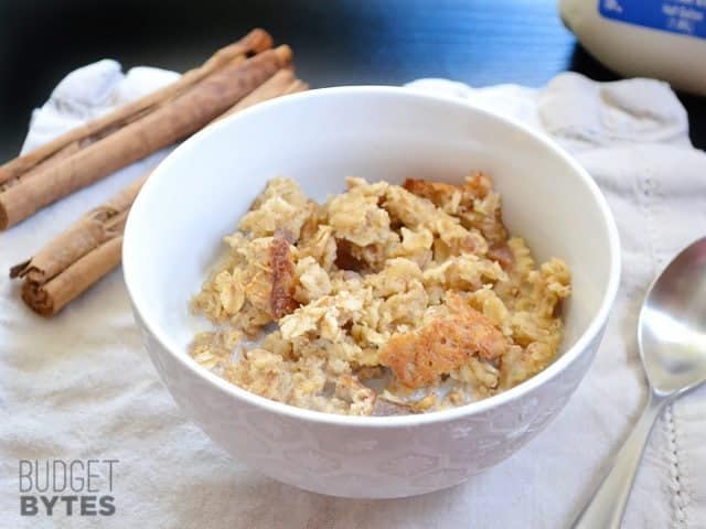 Side view of a bowl of Cinnamon Date & Walnut Oatmeal with a spoon on the side 