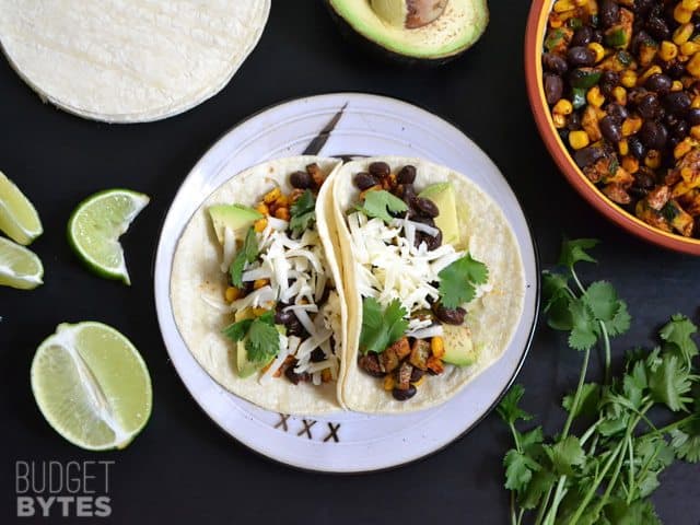 Corn and zucchini tacos garnished with cilantro.