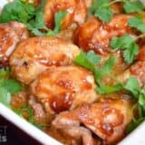 Sriracha-glazed chicken thighs on a plate.
