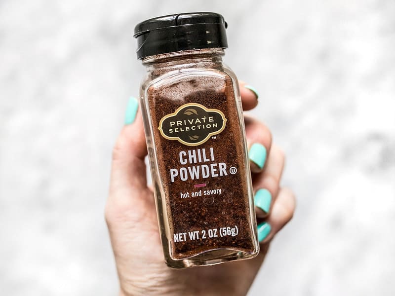 Bottle of chili powder being hand held. 