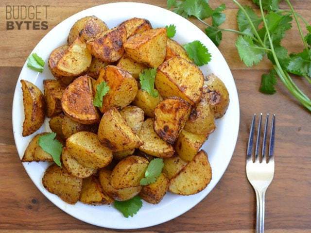 Top view of a bowl of Chili Roasted Potatoes with a fork on the side 