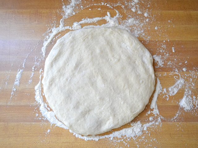 Pizza dough on floured counter top 