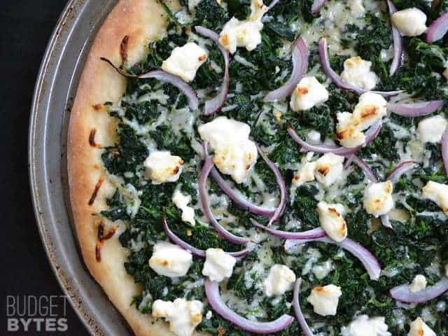 A close-up of spinach pizza with melted cheese.