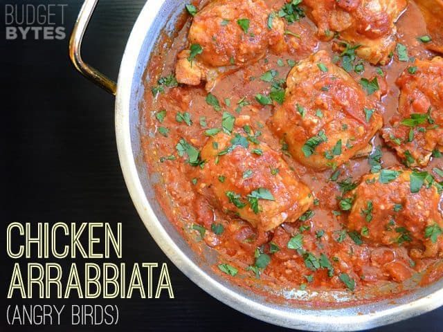 A saucepan of chicken arrabbiata pasta with herbs.