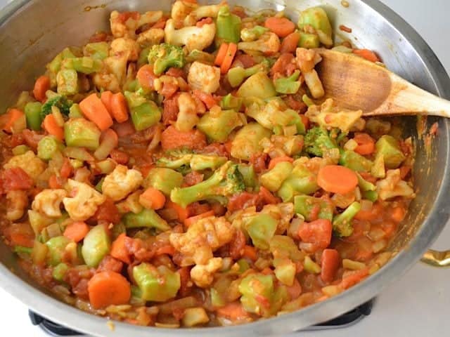 Frozen veggies added to other ingredients in skillet 