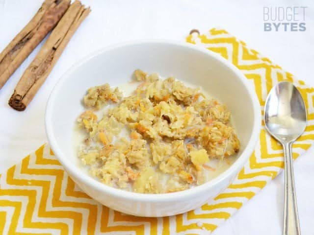 Top view of a bowl of Morning Glory Baked Oatmeal sitting on a yellow chevron napkin with a spoon on the side 