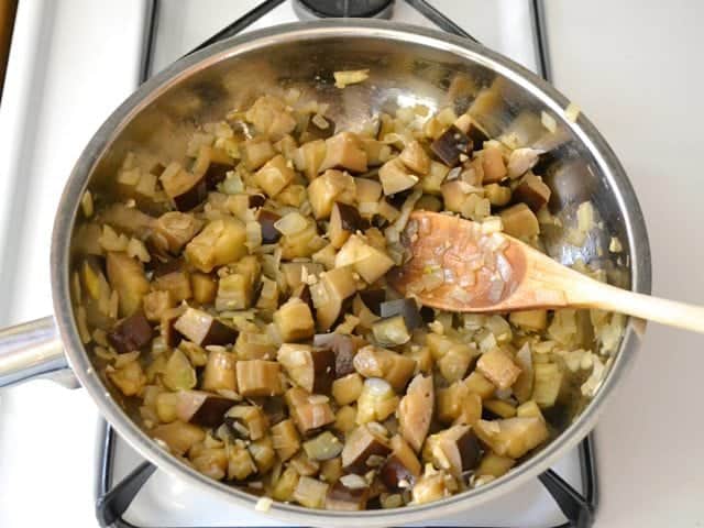 Cubed eggplant added to skillet with other ingredients 