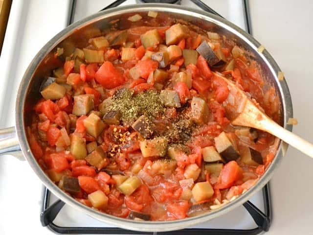 Tomatoes and seasonings added to skillet of other ingredients 