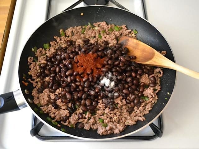 Beans and Seasoning added to other ingredients in skillet 