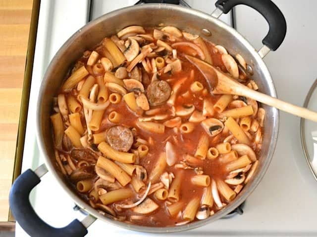 vegetable roth and cooked pasta added to veggies and sausage in pot 