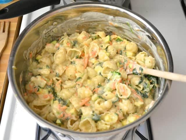 Cooked pasta and veggies added to pot of sauce 