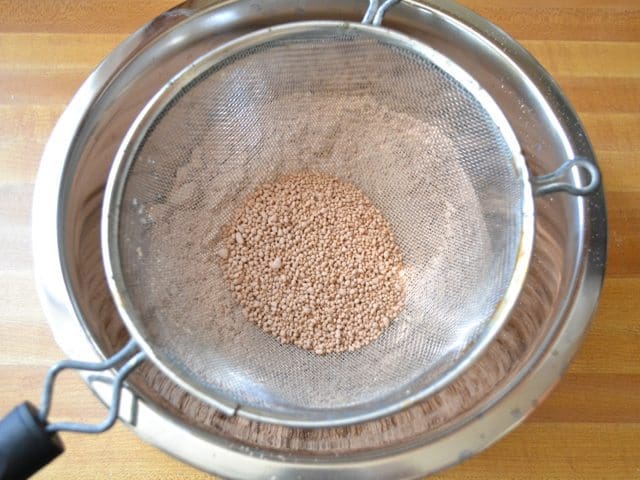 Sifting macaron shell mixture to get out any clumps 