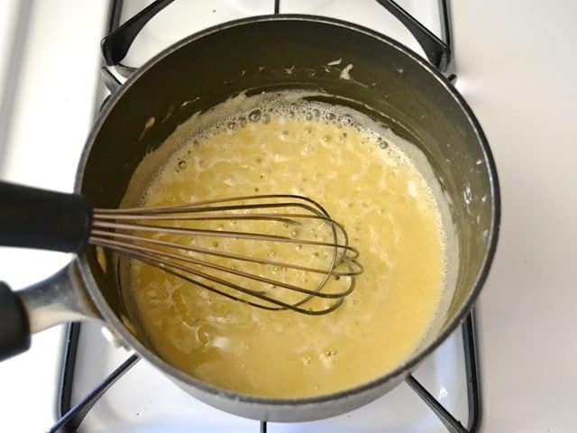 Sauce ingredients in pan with whisk 