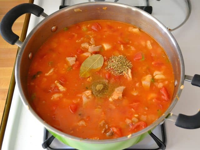 Tomatoes and chicken broth added to pot with other ingredients 