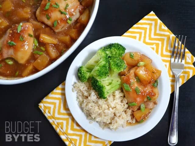 Pineapple Teriyaki Chicken plated with a side of broccoli and rice, full dish of chicken in background 