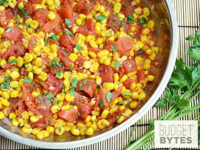 A close-up of sautéed corn and tomatoes in a bowl.