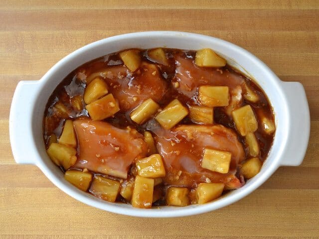 Sauce poured over raw chicken thighs in casserole dish 