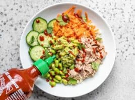 Add tuna, guacamole, sriracha, and sesame seeds to the bowl