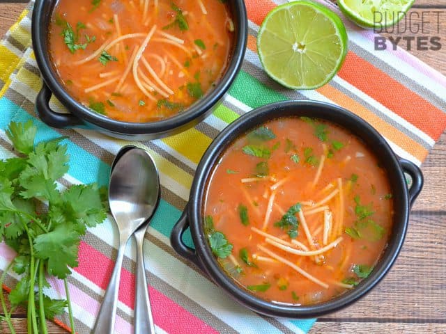 Bowls of sopa de fideo garnished with herbs.