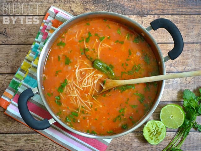 Top view of a pot of Sopa de Fideo with wooden spoon in pot 