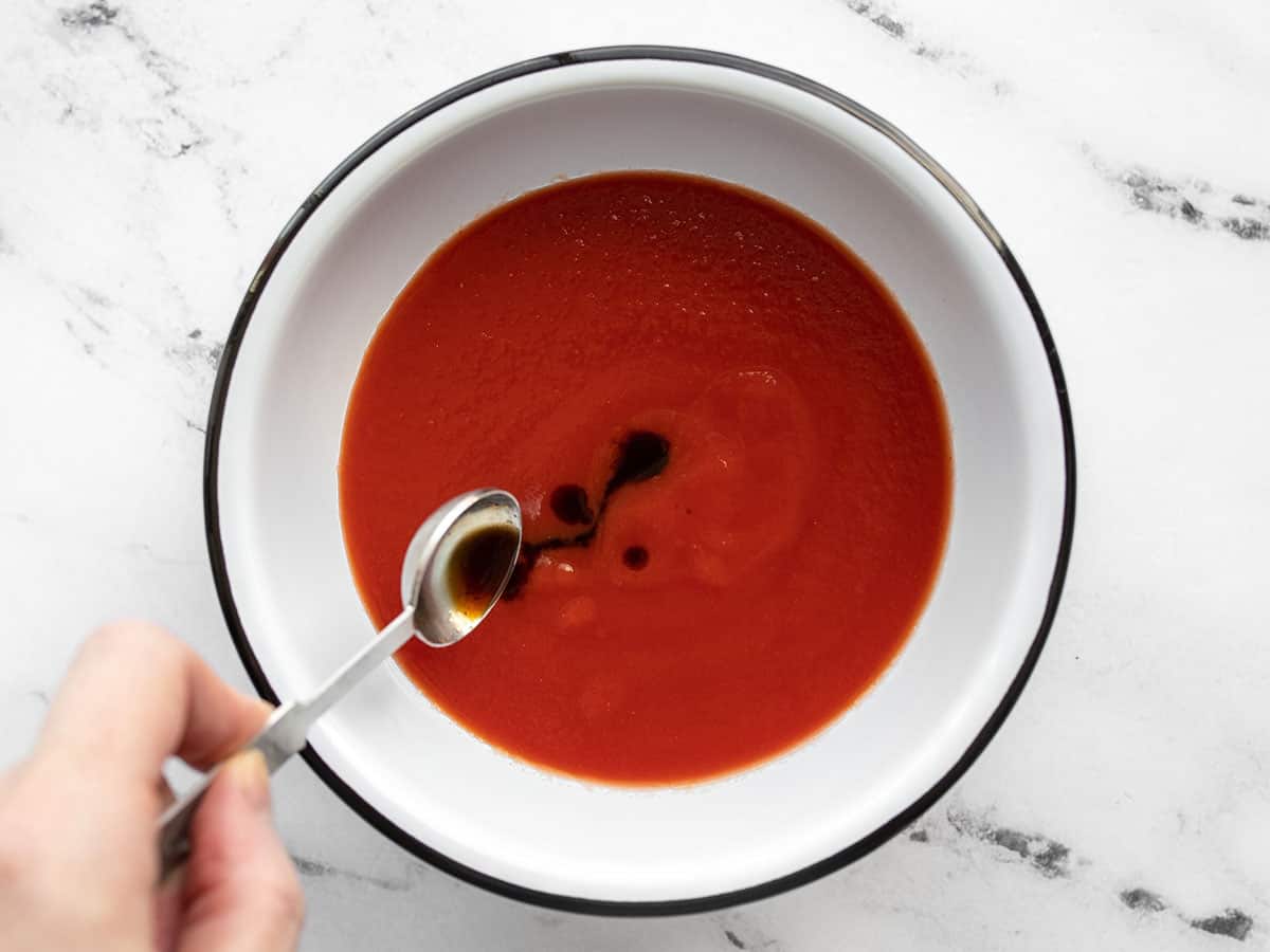 Worcestershire sauce being added to tomato sauce