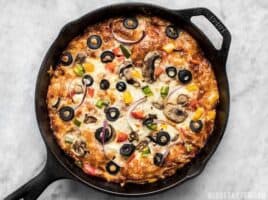 A simple overnight no knead dough makes a perfectly crispy yet thick crust on this no knead pan pizza. Deep dish pan pizza has never been easier. BudgetBytes.com