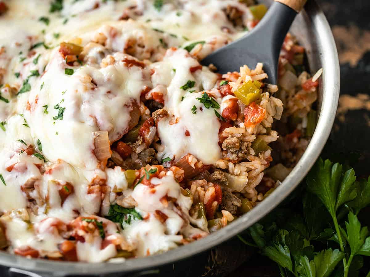 Close up side view of unstuffed bell peppers in the skillet