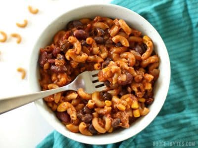 A bowl of one-pot chili pasta with a fork beside it.