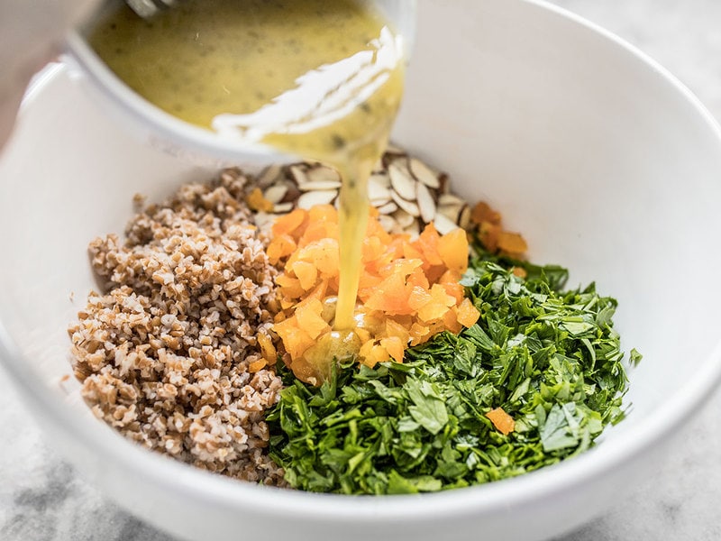 pouring dressing over Parsley Salad in bowl 