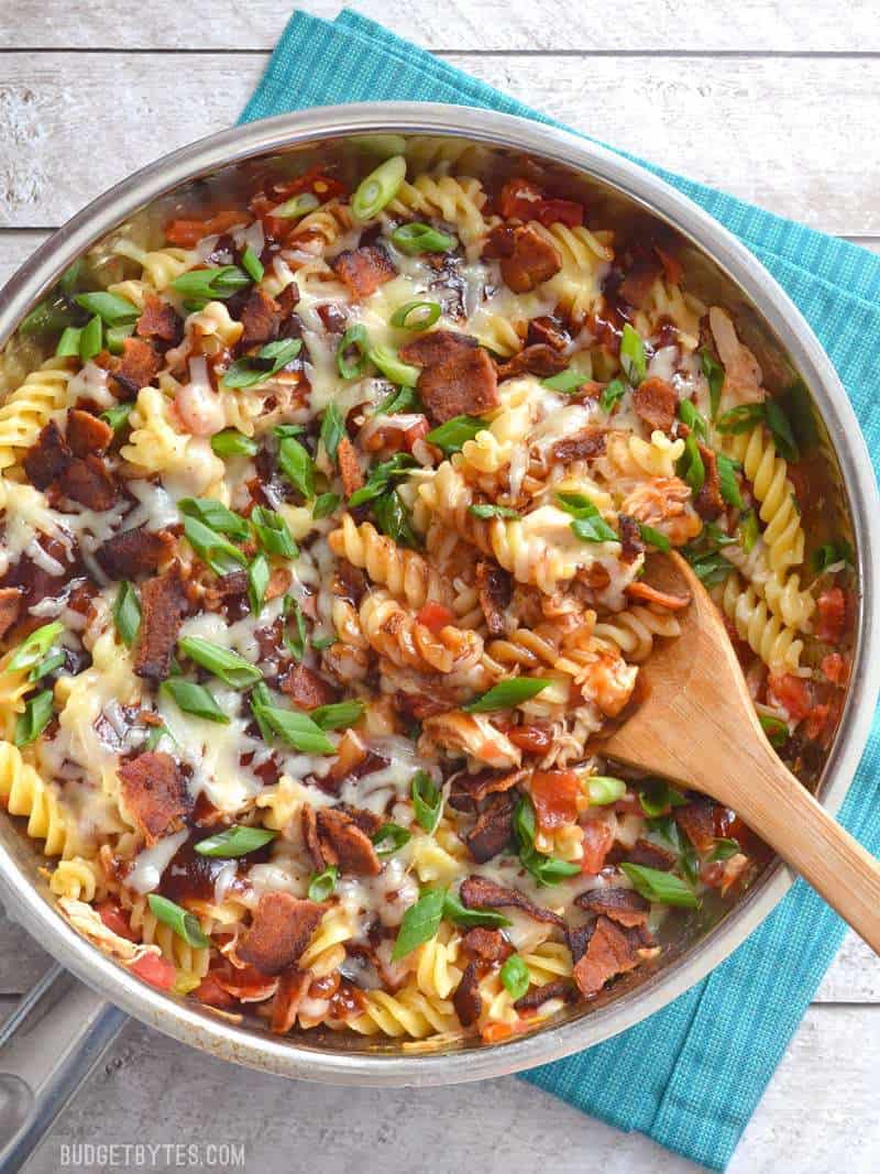 Top view of Monterey Chicken Skillet sitting on a blue striped napkin with a wooden spoon 