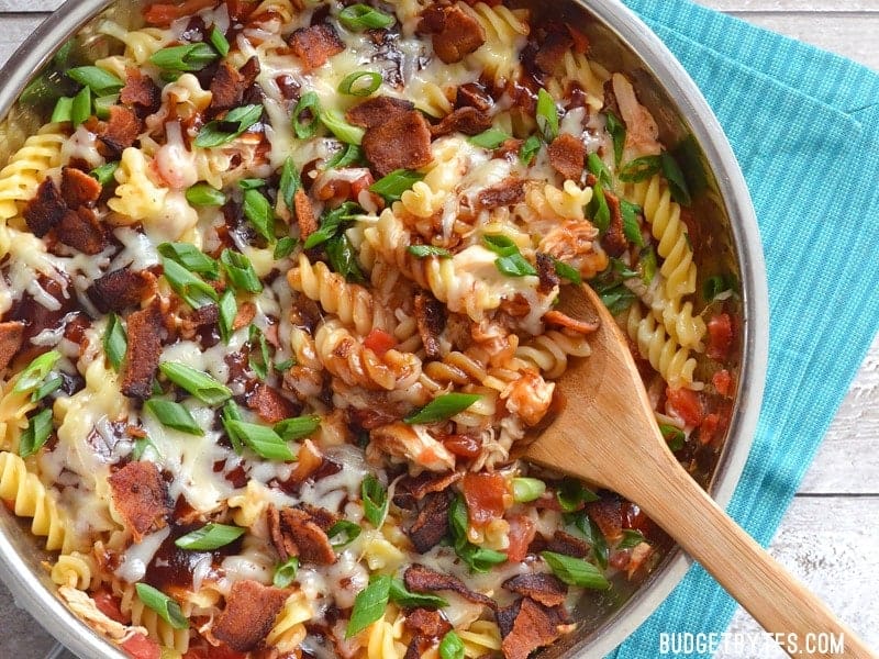 Wooden spoon scooping out a spoonful of pasta mixture 