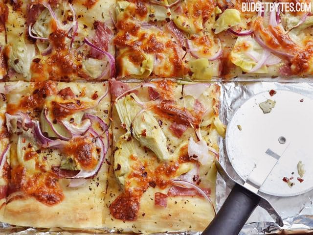 Spicy Italian Flat Bread on baking sheet, sliced into squares with pizza cutter 