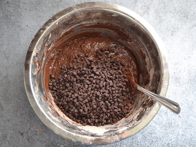 Chocolate Chips added to cookie dough in mixing bowl with fork 