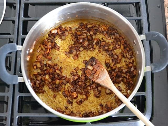 Spices added to garlic and onion in pot for seasoning 