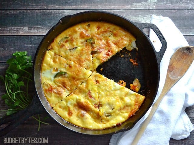 Slices of zucchini and corn frittata on a cast iron pan.