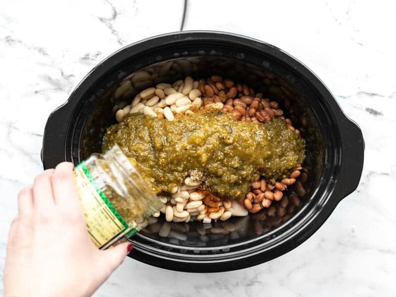 Salsa verde being poured into the slow cooker