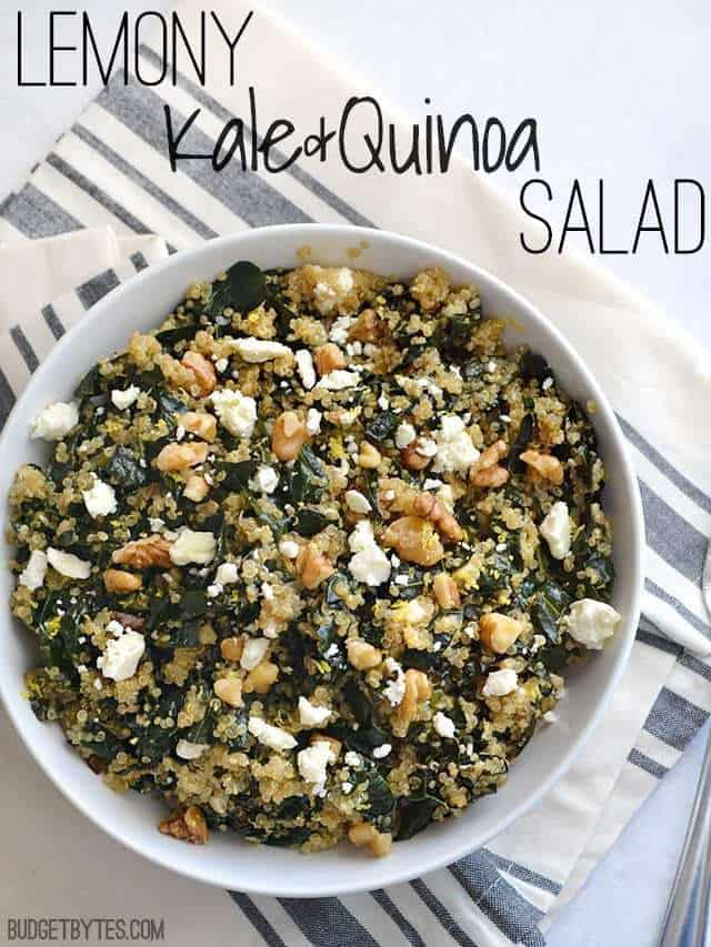 Top view of a bowl of Lemony Kale and Quinoa Salad sitting on a gray and white stripped napkin 