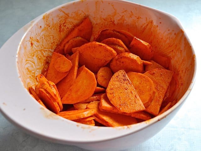 Spice mix poured over Sweet Potatoes to season 