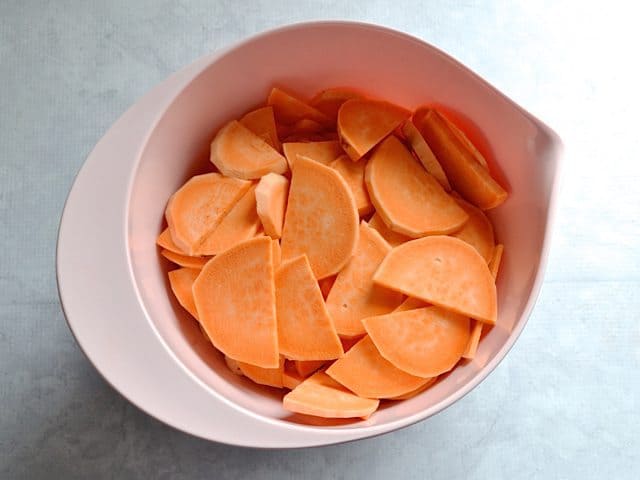 Peeled and Sliced Sweet Potatoes in pink mixing bowl 