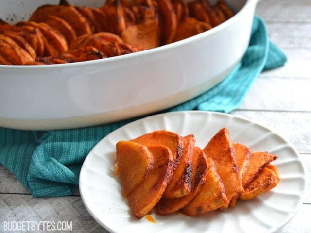 Plate of Smoky Roasted Sweet Potatoes with large dish in background 