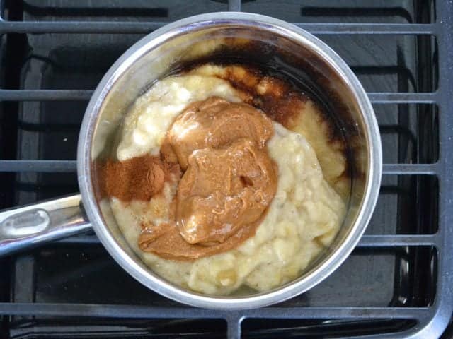 Sauce mixture and vanilla and cinnamon added to pot on stove top 