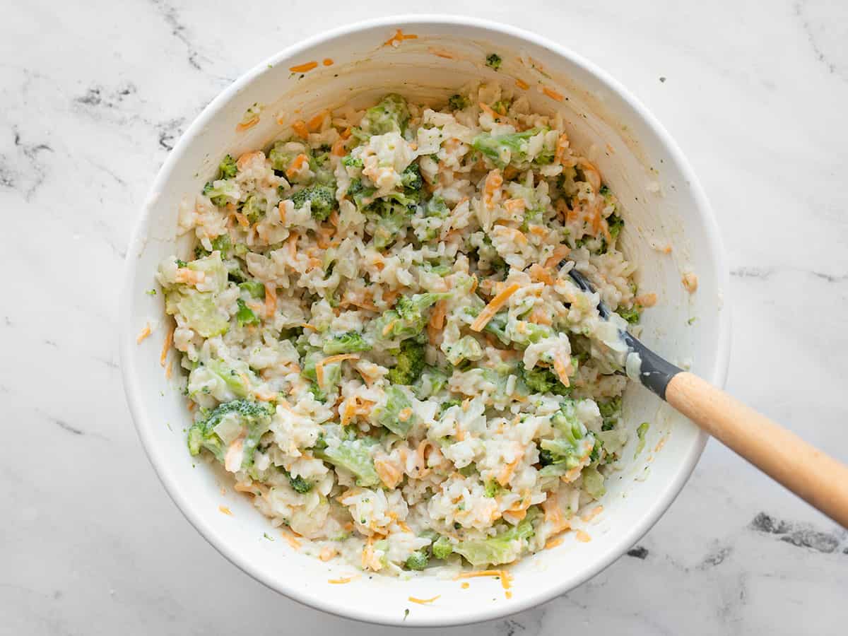 White sauce mixed in with broccoli, rice, and cheddar