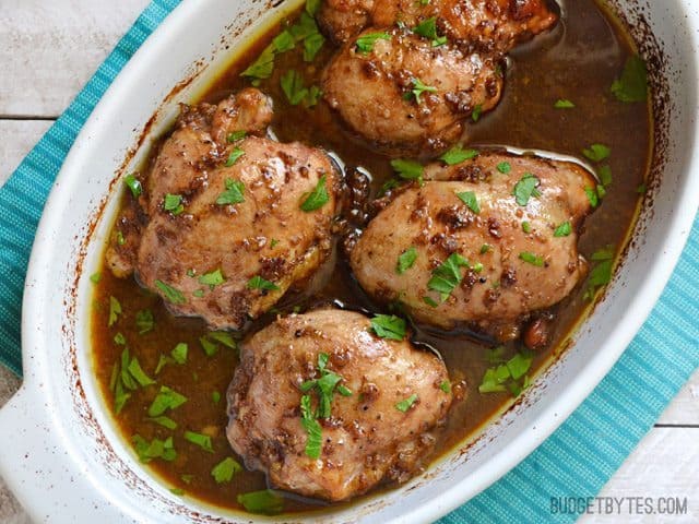 A close-up of balsamic chicken thighs on a serving dish.