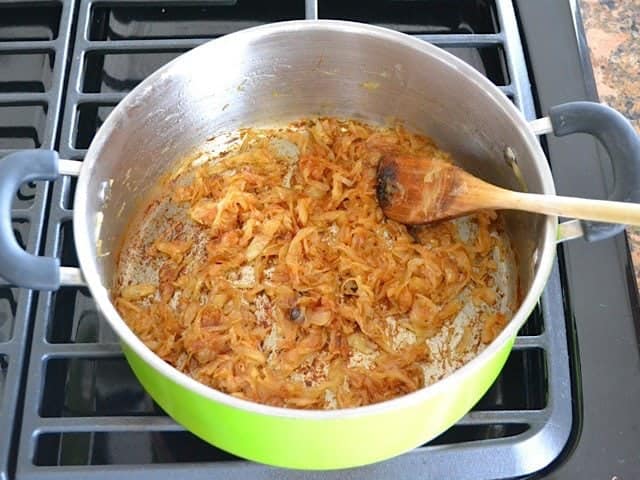 Caramelized Onions in pot, stirred with wooden spoon 