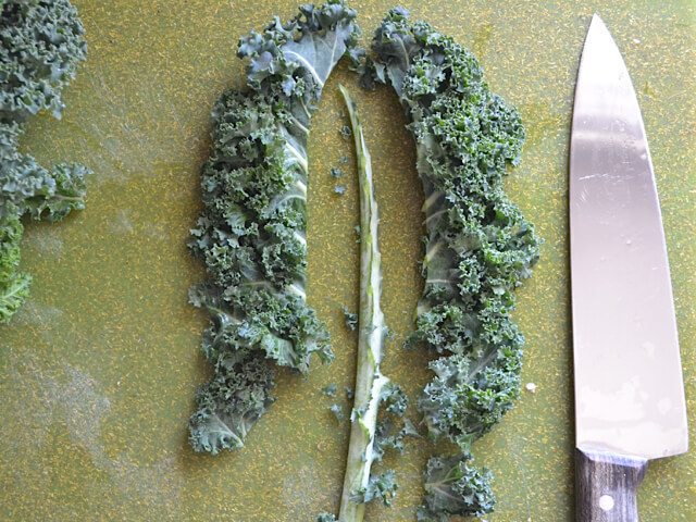 Removing the stems from kale with knife 