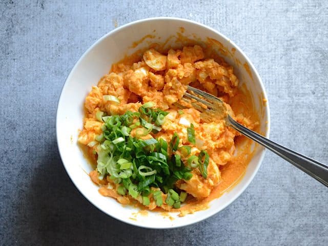 Deviled eggs mashed in bowl to make egg salad 