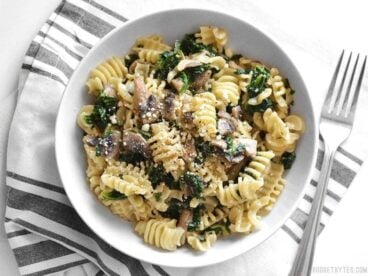 Parmesan & Pepper Kale Pasta is a quick and easy weeknight meal. Just a few ingredients transform boring pasta into a fancy meal. BudgetBytes.com