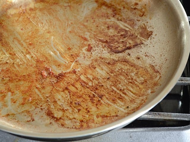 Skillet with flavor bits left over from browning pork chops 